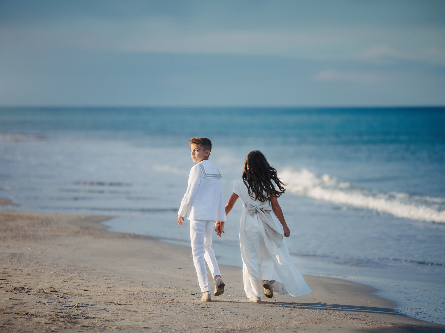 Niños paseando por la orilla del mar